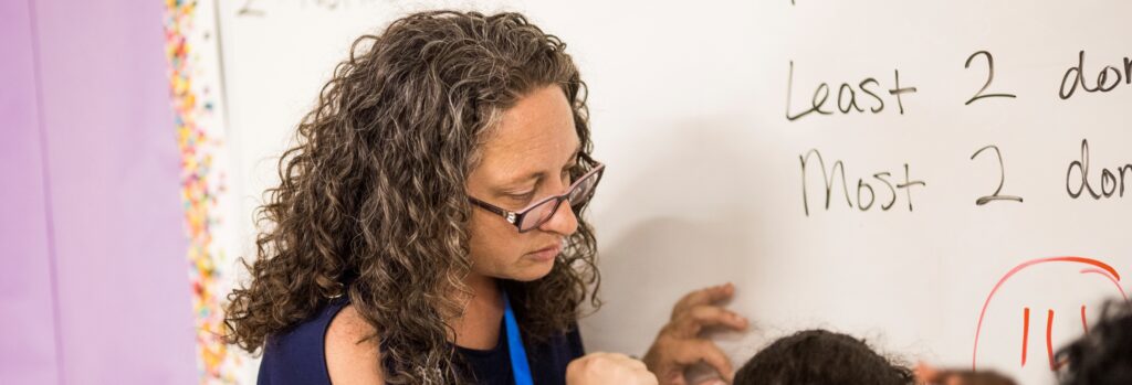 Third-grade teacher, Michelle Stillson, at a whiteboard teaching math